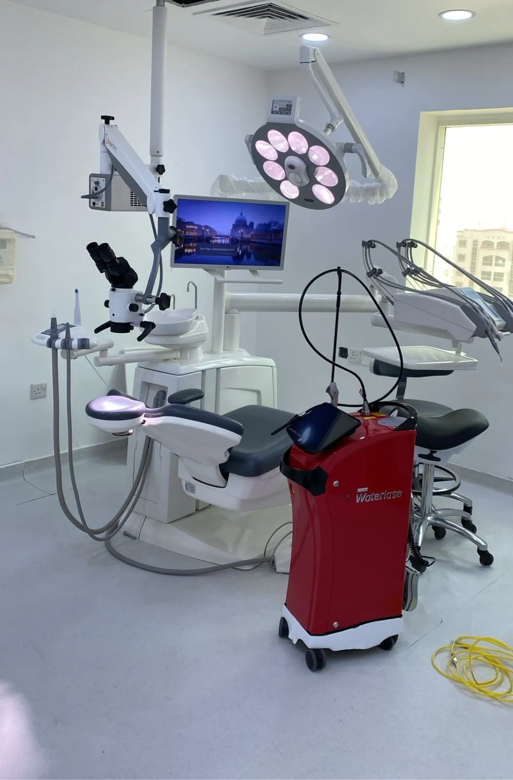 Treatment room with the operating microscope beside the dental chair and the Waterlase laser in front